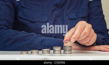 La main de la femme met des pièces sur pile. Étape de croissance croissante, économie d'argent, concept de financement d'investissement d'entreprise Banque D'Images