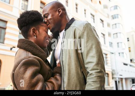 Couple afro-américain romantique profitant d'un moment tendre dans les rues de la ville pendant une journée ensoleillée Banque D'Images