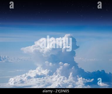 Vue aérienne depuis la fenêtre de l'avion à haute altitude de nuages denses de cumulus gonflés. Vue en haute altitude entre ciel et espace. Banque D'Images