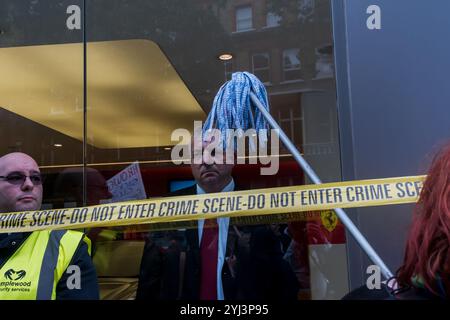 Londres, Royaume-Uni. 30 septembre 2017. Les manifestants dansent devant la salle d'exposition Ferrari du concessionnaire de voitures de luxe HR Owen de Kensington lors de la manifestation syndicale United Voices of the World pour réclamer la réintégration de leurs deux nettoyeurs suspendus sans salaire parce qu'ils ont demandé à être payés au salaire minimum de Londres pour le nettoyage des salles d'exposition Ferrari / Maserati. Les nettoyeurs Angelica Valencia et Freddy Lopez étaient soutenus par l'UVW et d'autres groupes, dont Class War et la RCG. Une centaine de manifestants ont défilé depuis la gare de South Kensington, manifestant brièvement devant les salles d'exposition Lamborghini et l'entrée des bureaux Banque D'Images