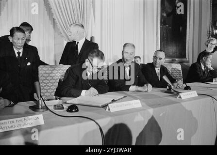 Signature du traité de coopération mutuelle avec le Japon, salle est de la Maison Blanche. Signature de copies du traité. La photographie montre le premier ministre japonais Nobusuke Kishi signant le traité de coopération mutuelle avec le Japon, alors que le secrétaire d'État Christian Herter, et d'autres regardent dans la salle est de la Maison Blanche, Washington, DC, États-Unis. 19 janvier 1960 Banque D'Images