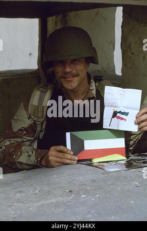 Première Guerre du Golfe : 10 mars 1991 Un soldat de l'armée américaine en service de garde sur le périmètre de l'ambassade des États-Unis à Koweït City affiche un message de remerciement de Kuwaitis reconnaissants. Banque D'Images