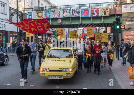 Londres, Royaume-Uni. 23 septembre 2017. Le reliant Robin, récemment acquis, « Precarious Workers Mobile », jaune vif, équipé d'un puissant amplificateur et d'un haut-parleur, mène les grévistes et partisans dans une lente marche autour du centre de Brixton alors qu'ils célèbrent une année de grève. Les grévistes du BECTU exigent que le salaire de subsistance de Londres, les indemnités de maladie, les indemnités de maternité et de paternité, que les gestionnaires, les superviseurs, les chefs et le personnel technique soient correctement évalués pour leur travail, et que les quatre représentants syndicaux licenciés soient réintégrés. Banque D'Images