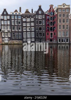 Maisons de canal sur le Damrak avec reflet dans l'eau dans le centre de la vieille ville, Amsterdam, Hollande du Nord, pays-Bas Banque D'Images
