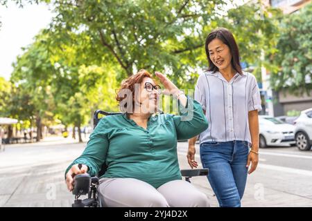 Femme handicapée parlant avec des amis chinois tout en marchant le long d'une rue piétonne dans la ville Banque D'Images