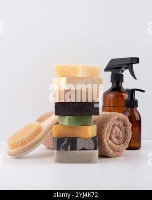 Pile de pains de savon naturel, brosse de corps en bois, serviette et flacon pulvérisateur dans un style minimaliste. Idéal pour les thèmes de soin de la peau et de bien-être respectueux de l'environnement. Susta Banque D'Images