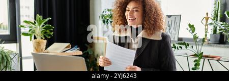 La femme sourit brillamment alors qu'elle examine des documents importants dans son élégant bureau à domicile. Banque D'Images