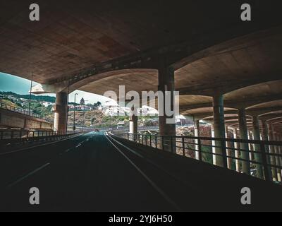 Vue de dessous la piste de l'aéroport de Santa Cruz, avec des colonnes en béton soutenant la structure, Madère. Banque D'Images