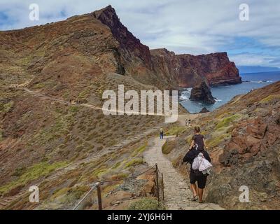 Randonneurs sur un sentier accidenté le long des falaises spectaculaires de Ponta de São Lourenço, Madère, avec vue sur la côte. Banque D'Images