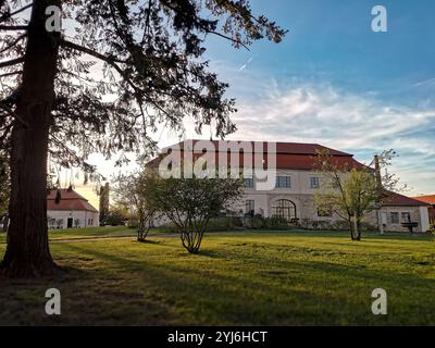 Domaine paisible à Kravsko, République tchèque, entouré d'arbres et de verdure avec un bâtiment traditionnel sous un ciel clair. Banque D'Images