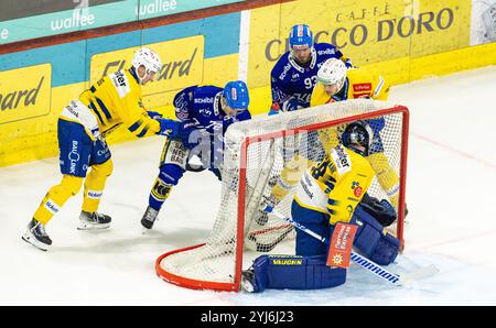 Kloten, Suisse, 13 novembre 2024 : le gardien #29 Sandro Aeschlimann (Davos) regarde le combat derrière le but pour la rondelle posée sur le filet de but. Les joueurs impliquaient le #72 Keijo Weibel et le #93 Nolan Diem (tous deux Kloten), ainsi que le #77 Nico Gross et le #12 Enzo Gueby (tous deux Davos). (Photo de Andreas Haas/dieBildmanufaktur) crédit : dieBildmanufaktur/Alamy Live News Banque D'Images