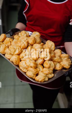 Pâtisseries à choux fraîchement cuites sur un plateau, parfaites pour les desserts ou les étalages de boulangerie Banque D'Images