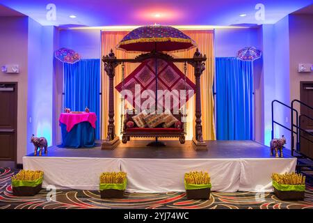 Scène de cérémonie indienne colorée de pré-mariage avec parapluies traditionnels et banc pour les rituels de mariage hindous Banque D'Images