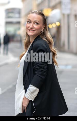 Portrait d'une femme sophistiquée d'apparence européenne, 35-40 ans, avec un flou d'une ville moderne en arrière-plan. Banque D'Images