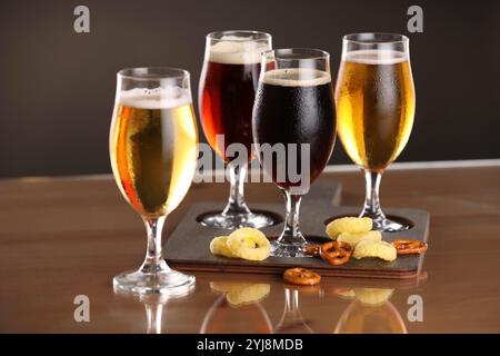 Verres avec différents types de bière et collations sur la table Banque D'Images