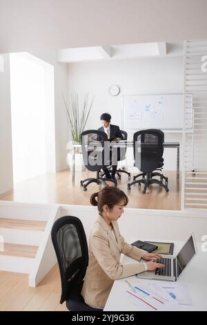 Homme et femme assis dans le bureau avec plancher de saut Banque D'Images