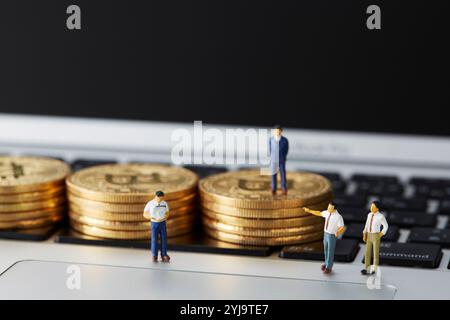 Bitcoins et miniatures empilés sur le dessus du clavier Banque D'Images