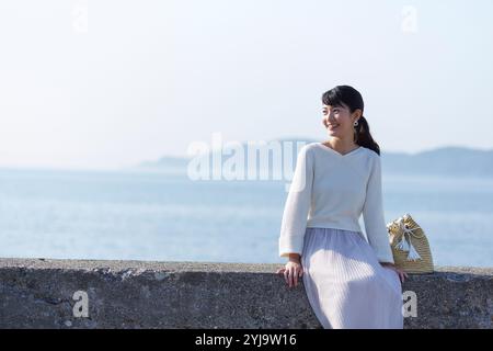 Femme assise sur un remblai Banque D'Images