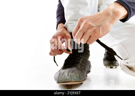 Homme en uniforme de baseball nouant des lacets de chaussures Banque D'Images