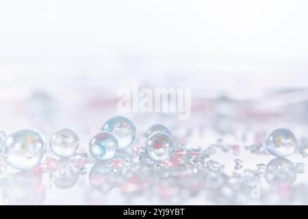 Plusieurs grains de verre et billes de verre placés sur une plaque réfléchissante Banque D'Images