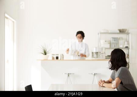 Homme et femme se relaxant dans la salle à manger et la cuisine Banque D'Images