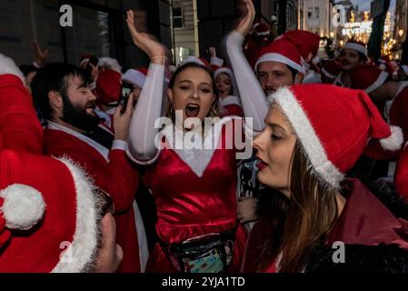 Londres, Royaume-Uni. 8th December 2018.des foules de personnes vêtues de costumes de Père Noël, avec l'elfe étrange et les rennes ont fait leur chemin vers Trafalgar Square répandant des nouvelles heureuses alors que l'obscurité est tombée, certains suivant des systèmes de son tirés à la main et dansant dans les rues, bien que de nombreux groupes ont été détournés dans les pubs et les magasins d'alimentation sur le chemin. Beaucoup portaient des bouteilles ou des canettes et tous étaient de bonne humeur. Santacon avait commencé à 11h à plusieurs endroits différents et est un événement caritatif annuel, cette année soutenant Christmas for Kids. Banque D'Images