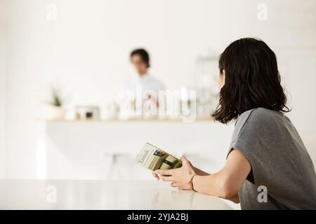 Homme et femme se relaxant dans la salle à manger et la cuisine Banque D'Images