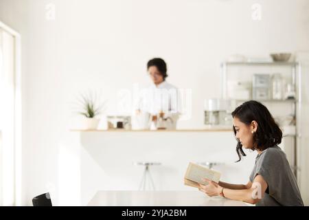 Homme et femme se relaxant dans la salle à manger et la cuisine Banque D'Images