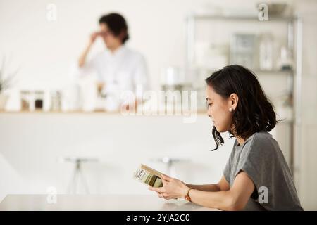 Homme et femme se relaxant dans la salle à manger et la cuisine Banque D'Images