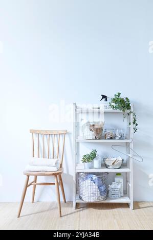 Porte-linge et chaise devant le mur blanc Banque D'Images