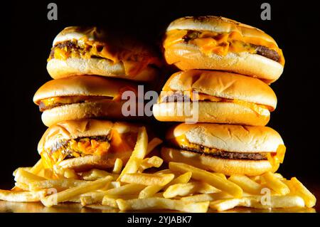 Photo de dossier datée du 09/07/14 d'une photo générique montre une pile de cheeseburgers et de frites. Le système alimentaire britannique pousse «sans relâche» les consommateurs à faire des choix malsains, selon un rapport annuel de l'association caritative Food Foundation. Date d'émission : jeudi 14 novembre 2024. Banque D'Images