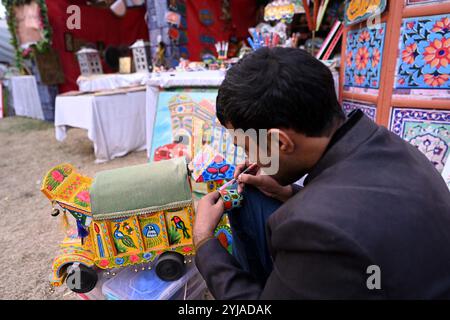 Islamabad, Pakistan. 13 novembre 2024. Un artiste peint sur une tasse lors du festival Lok Mela à Islamabad, capitale du Pakistan, le 13 novembre 2024. Le festival folklorique annuel, connu sous le nom de Lok Mela, a lieu dans la capitale pakistanaise Islamabad du 8 au 17 novembre. Cet événement de dix jours offre une plateforme aux artistes de partout au pays pour présenter leurs œuvres artistiques et leurs performances. Crédit : Ahmad Kamal/Xinhua/Alamy Live News Banque D'Images