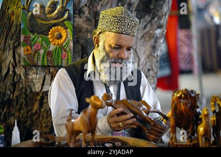 Islamabad, Pakistan. 13 novembre 2024. Un artiste fabrique de l'artisanat en bois lors du Festival Lok Mela à Islamabad, capitale du Pakistan, le 13 novembre 2024. Le festival folklorique annuel, connu sous le nom de Lok Mela, a lieu dans la capitale pakistanaise Islamabad du 8 au 17 novembre. Cet événement de dix jours offre une plateforme aux artistes de partout au pays pour présenter leurs œuvres artistiques et leurs performances. Crédit : Ahmad Kamal/Xinhua/Alamy Live News Banque D'Images