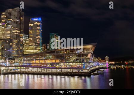 Vancouver, Canada - 3 janvier 2024 : Vancouver Convention Centre la nuit avec un toit incliné emblématique, installé contre les gratte-ciel illuminés du centre-ville Banque D'Images