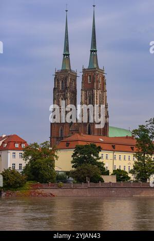 Cathédrale historique à deux flèches à Wroclaw avec l'élévation du niveau de l'eau de la rivière après de fortes pluies par une journée nuageuse Banque D'Images