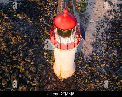 Vue aérienne du phare blanc avec un chapeau rouge assis sur un récif rocheux sur Griffith Island à Port Fairy sur la Great Ocean Road à Victoria, Australie Banque D'Images