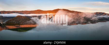 Vue panoramique aérienne du lever du soleil sur un lac de montagne brumeux à Howqua Inlet sur le lac eildon à Victoria, Australie. Banque D'Images
