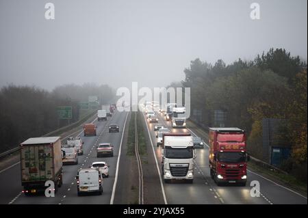 Cambridge, Royaume-Uni. 14 novembre 2024. Du brouillard est vu au-dessus de l'autoroute A14 à Cambridge. Selon le bureau DU MET, l'est de l'Angleterre va voir un début de journée nuageux avec une pluie légère inégale se dégageant vers le sud, devenant sèche avec des périodes ensoleillées se développant progressivement tout au long de la matinée. Crédit : David Tramontan / Alamy Live News Banque D'Images