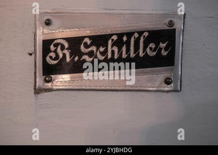 Namensschild R. Schiller an einer Kirchenbank Namensschild R. Schiller an einer Kirchenbank in der Sophienkirche von Pokoj/Bad Carlsruhe, Woiwodschaft Opole, Polen. Banque D'Images