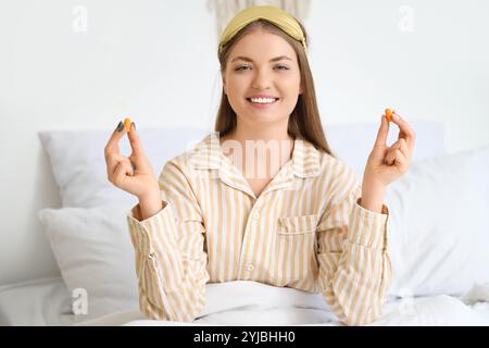 Jeune femme avec des bouchons d'oreilles dans la chambre Banque D'Images