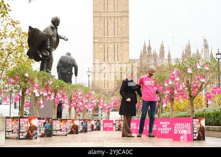 USAGE ÉDITORIAL SEULEMENT Sophie Blake et Anil Douglas visitent des arbres portant 650 vœux mourants placés à Parliament Square, Londres, par Dignity in Dying, un groupe de campagne soutenant la légalisation de l'aide à mourir pour les adultes mentalement malades en phase terminale, en prévision du débat de la Chambre des communes du 29 novembre sur le projet de loi d'initiative parlementaire de Kim Leadbeater sur l'aide à mourir. Date de la photo : jeudi 14 novembre 2024. Média PA. Leur campagne «My Dying Wish» a rassemblé les souhaits de personnes en phase terminale, qui ont été attachés à 17 arbres, symbolisant le fait que 17 personnes souffrent chaque jour dans cet arbre Banque D'Images