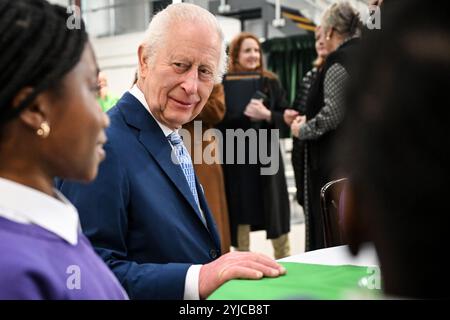 Le roi Charles III s’entretient avec des élèves de l’école primaire de Rye Oak alors qu’il visite le First Coronation Food Hub à Deptford, au sud de Londres. Le Roi célèbre son 76e anniversaire et le premier anniversaire du Coronation Food Project en ouvrant les deux premiers centres alimentaires Coronation, l’un en personne et l’autre virtuellement à Merseyside. Date de la photo : jeudi 14 novembre 2024. Banque D'Images