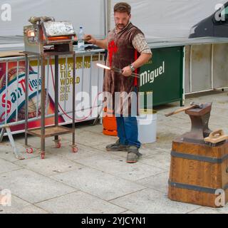 Forgeron prenant un fer à cheval rouge chaud d'un four à gaz lors d'une exposition publique à El CID fiestas Burgos Castile & Leon Espagne Banque D'Images