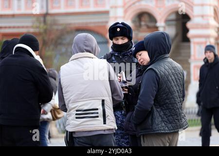 Des policiers russes vérifient les documents des migrants sur la place Rouge Banque D'Images
