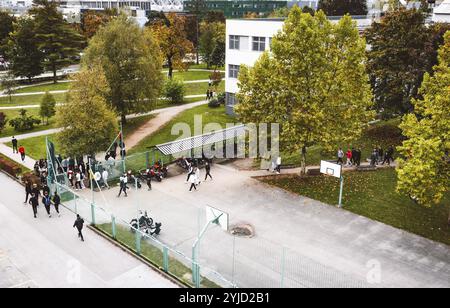 Vue aérienne des étudiants marchant à l'extérieur sur le campus allant et sortant de la classe. Jour d'automne, beaucoup d'arbres et d'herbe verte sur le campus Banque D'Images