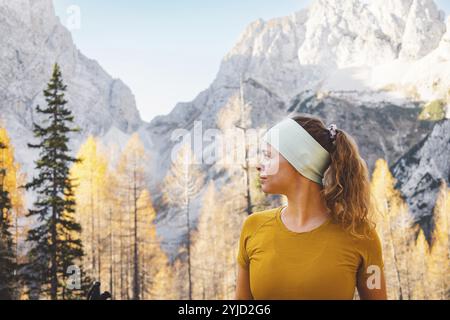 Femme à la taille, fille de randonneur d'automne d'automne en plein air dans la forêt fixant son bandeau. Heureuse femme caucasienne faisant de la randonnée en plein air. Banque D'Images