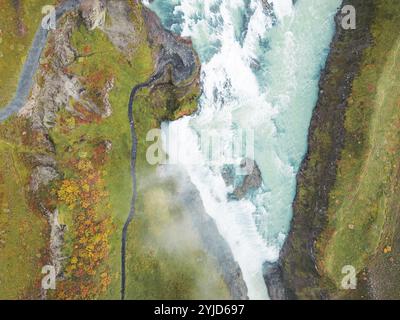 Énorme belle cascade Gullfoss, célèbre monument en Islande. La rivière moussait en tombant dans la cascade, les touristes marchant à côté, regardant la Wate Banque D'Images