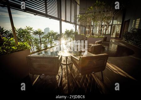 Terrasse sur le toit de l'hôtel de luxe avec zone chill out et plantes éclairées par le soleil Banque D'Images