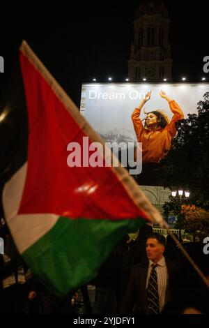 Une publicité sur un bâtiment qui dit "Dream on" apparaît avec un drapeau palestinien au premier plan, lors de la manifestation pro-palestinienne contre l'organisation du gala pro-israélien "Israël est pour toujours" à Paris. Des milliers de personnes ont manifesté à Paris contre le gala organisé par l’extrême droite en soutien à Israël, « Israël est pour toujours ». Le rassemblement, sous forte surveillance policière, était organisé par des partis de gauche et des syndicats, des mouvements juifs de gauche et des groupes pro-palestiniens. Bezalel Smotrich, le ministre israélien des Finances, connu pour ses positions extrêmes sur Gaza, qui devait le faire Banque D'Images