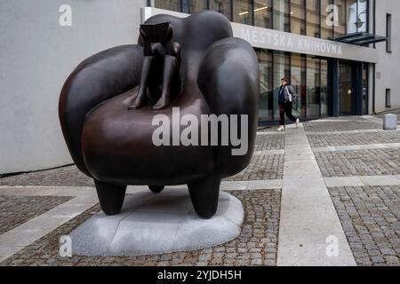 Rakovnik, République tchèque. 14 novembre 2024. Le peintre et sculpteur Jaroslav Rona (non vu) a dévoilé sa sculpture "le lecteur dans la chaise" devant le bâtiment du Centre d'études et de services sociaux polyvalents à Rakovnik, république tchèque, le 14 novembre 2024. Crédit : Ondrej Deml/CTK photo/Alamy Live News Banque D'Images